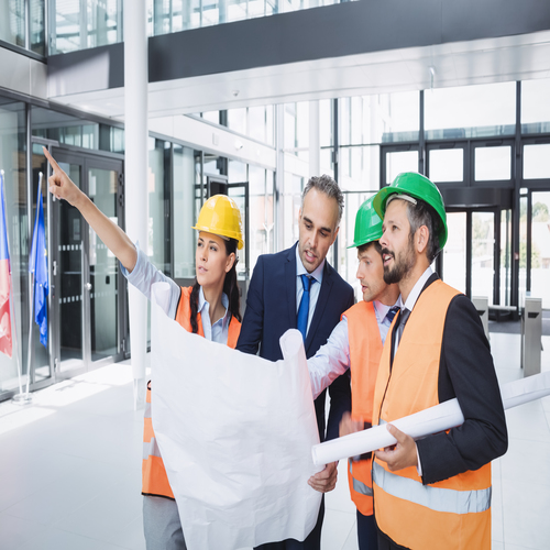 Businessman discussing on blueprint with architects in office building
